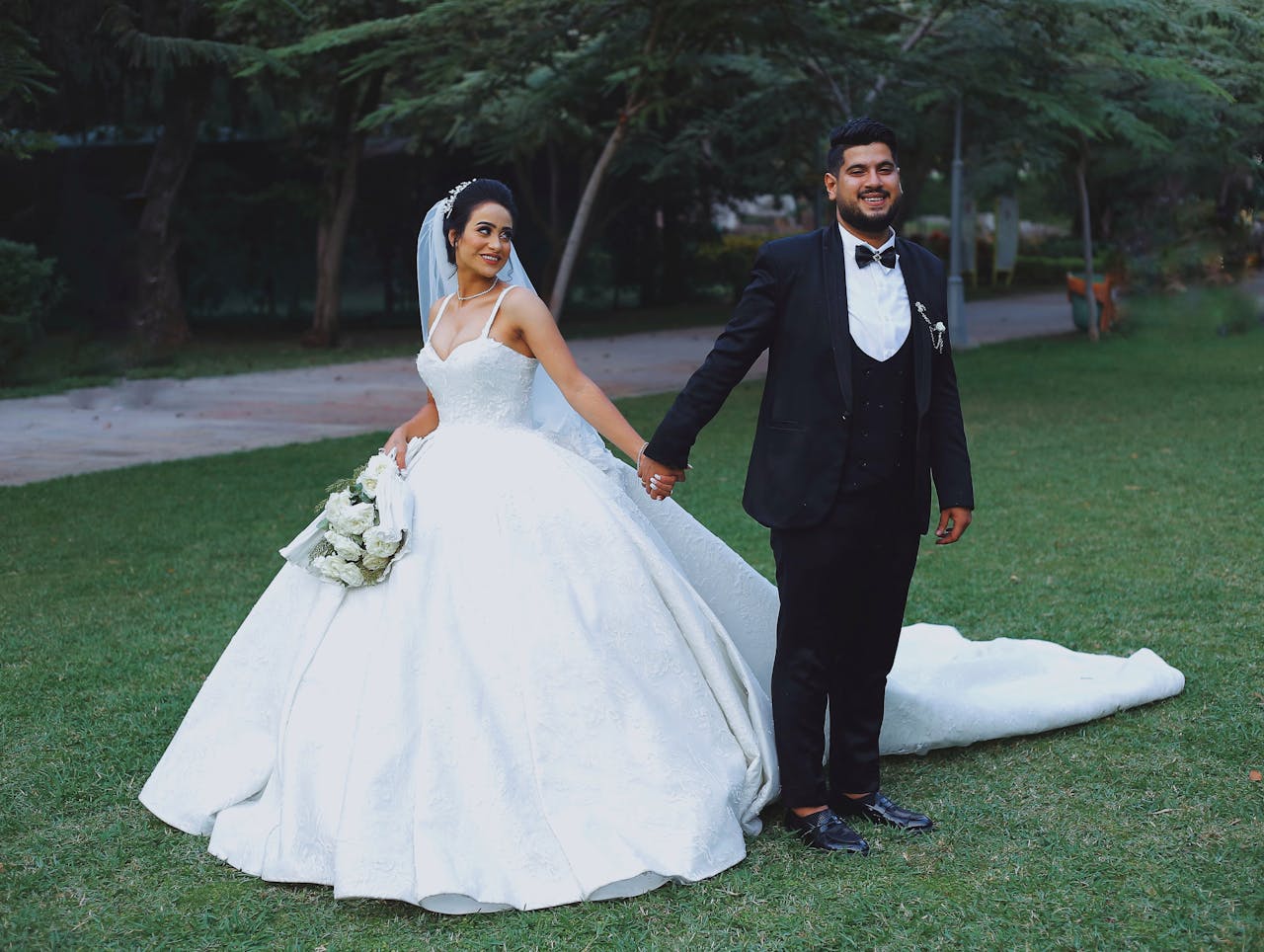 The Art of Drawing Readers In: Your attractive post title goes here A joyful couple holding hands outdoors, bride in a gown, groom in a suit.