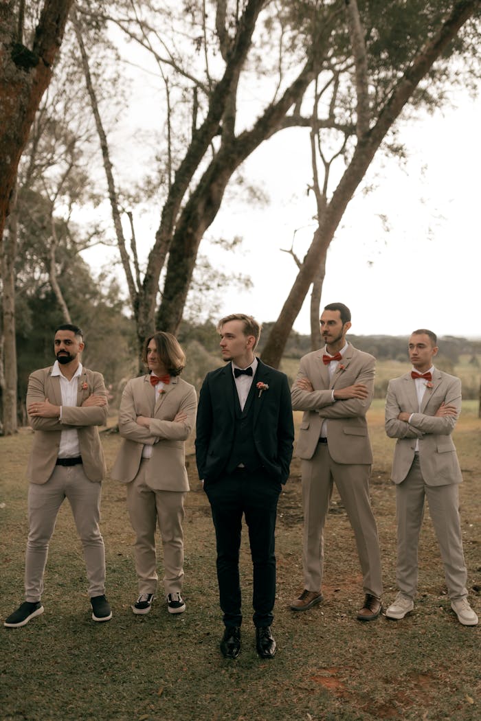 Crafting Captivating Headlines: Your awesome post title goes here Groom with his groomsmen posing in an outdoor setting, showing elegance and style on a special day.